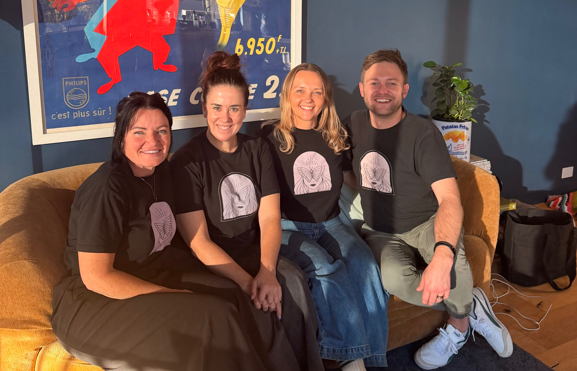 The Find My Wild team together on a couch wearing matching tees